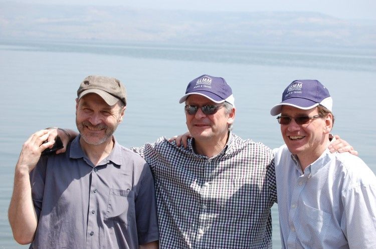Roger Greene, left, with fellow directors Simon Thane (centre) and Alastair Mitchell-Baker on the shore of the Church of St Peter's Primacy, purportedly where Jesus told his disciples to "let down their nets on the othe4r side"