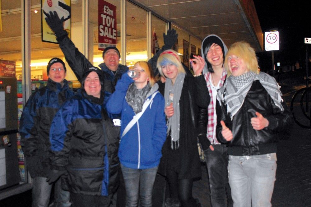 Young revellers in Hastings flanked by three street pastors (left)