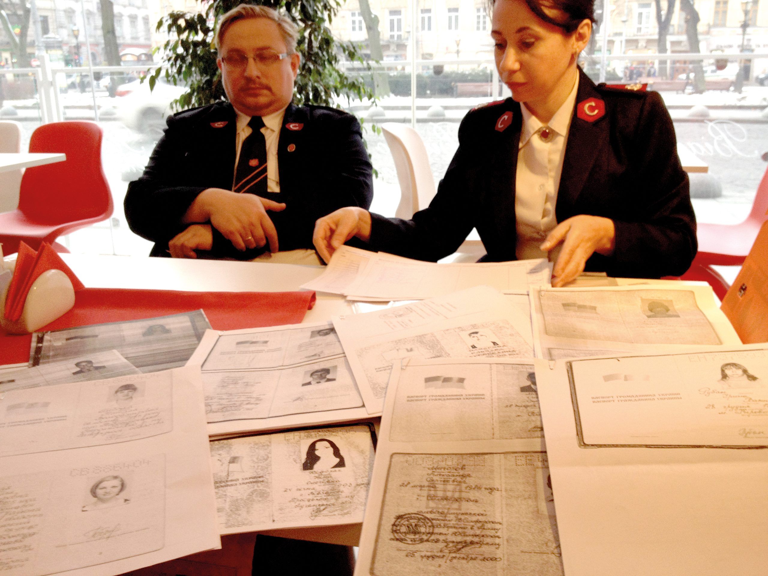 Swamped by paperwork: two of Ukraine’s highest ranking Salvation Army officers have to process a pile of identity documents so that refugees can receive food parcels and clothes