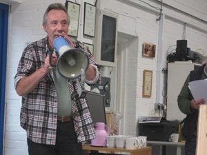 Simon in his warehouse with megaphone