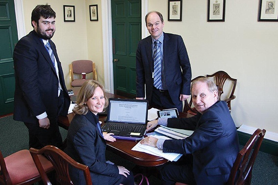 Lord Morrow (seated), made no secret of his Christian faith and saw his bill against trafficking ‘overwhelmingly’ voted into law with help from CARE’s Public Policy Team. From left, Mark Baillie, Louise Gleich and Dr Dan Boucher (standing) helped mobilise Christians to lobby and pray