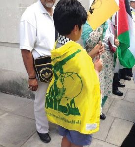 Peaceful demonstration? A child wrapped in a Hezbollah flag with assualt rifle image clearly visible Picture: Christians United for Israel