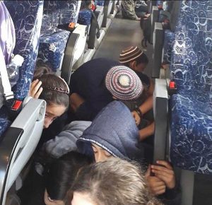 Terrified schoolchildren huddle in the aisle of their bus while the road near Gan Yavneh was bombed