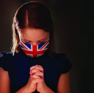 Pray for UK. Child in face mask praying for Great Britain. Little British girl in hospital chapel or church during coronavirus outbreak. Virus pandemic. Kids worship. Children say a prayer. “Three years of great humbling will come upon this nation…”