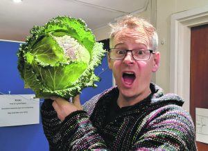 Pastor Chris holds a cabbage