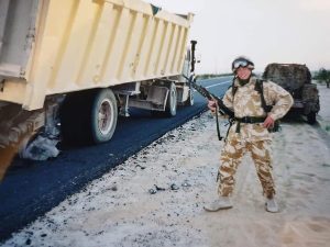 Bruce McEwen with a military vehicle in the Iraqi desert
