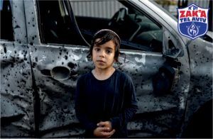 A little boy in front of the family car hit by rockets from Gaza 